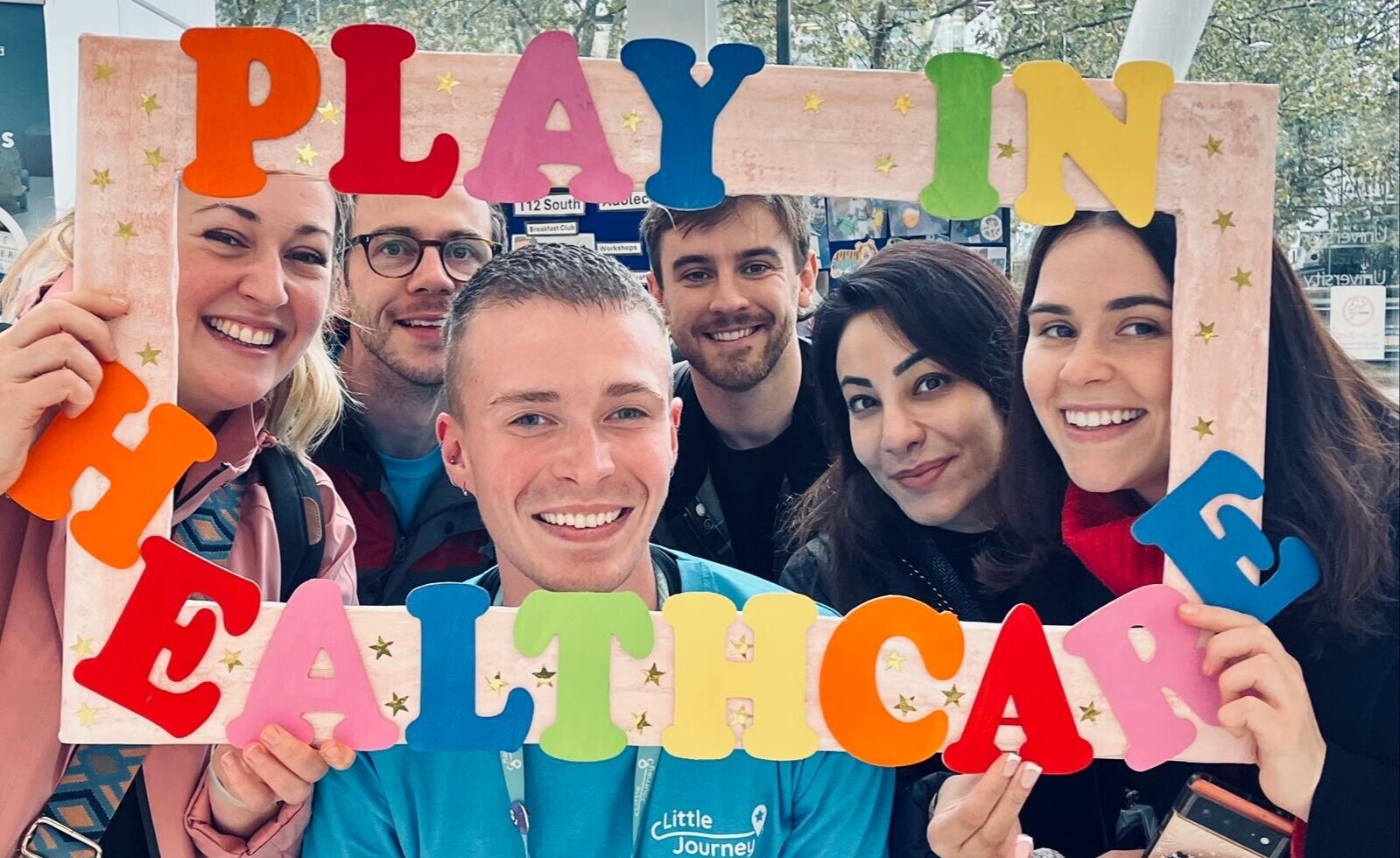 6 people smiling with their faces in a frame that says 'Play in Healthcare'